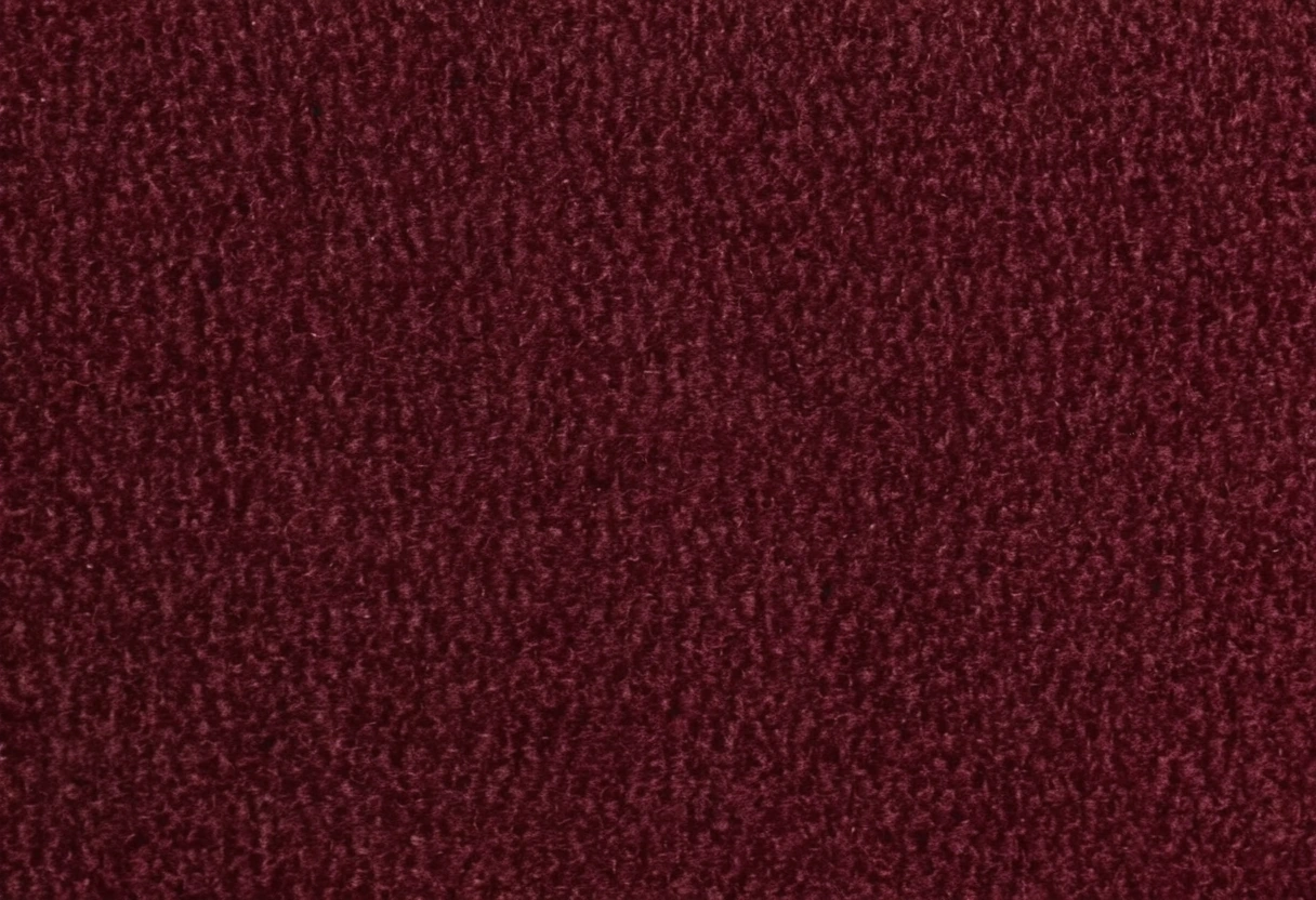 Close-up of oxblood velvet upholstery against a dark lacquered timber edge